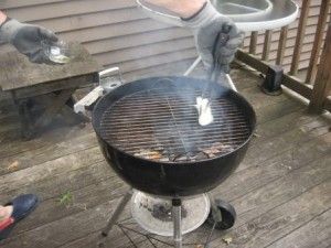 Wiping grill grate with an oiled paper towel