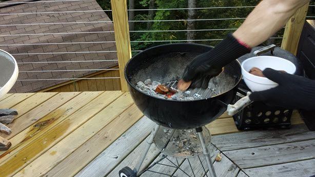 Apple Smoke houtsnippers op kolen gooien met mijn Weber Grill handschoenen