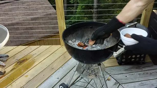 Tossing Apple Smoke Wood Chips onto the coals with my Weber Grill Gloves